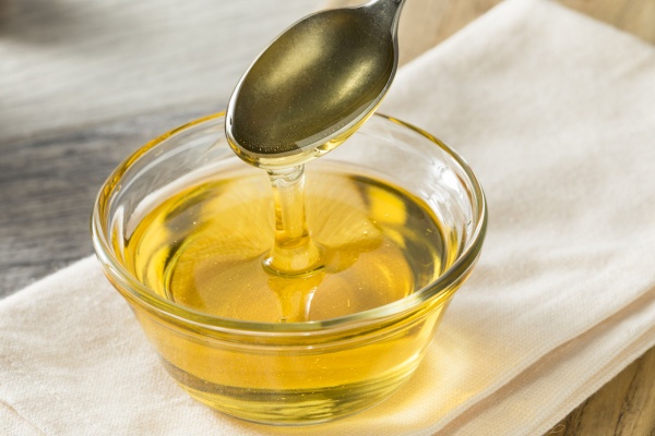 Glukózový sirup stékající ze lžíce do misky